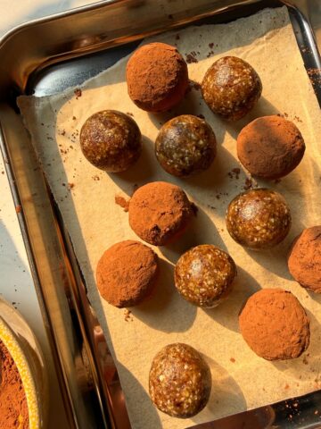 Rolling the energy bites in cocoa powder.