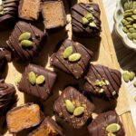 Top down view of caramels decorated with pumpkin seeds and pumpkin pie spice.