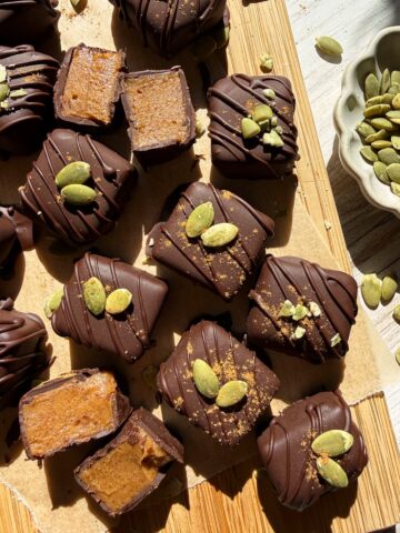 Top down view of caramels decorated with pumpkin seeds and pumpkin pie spice.
