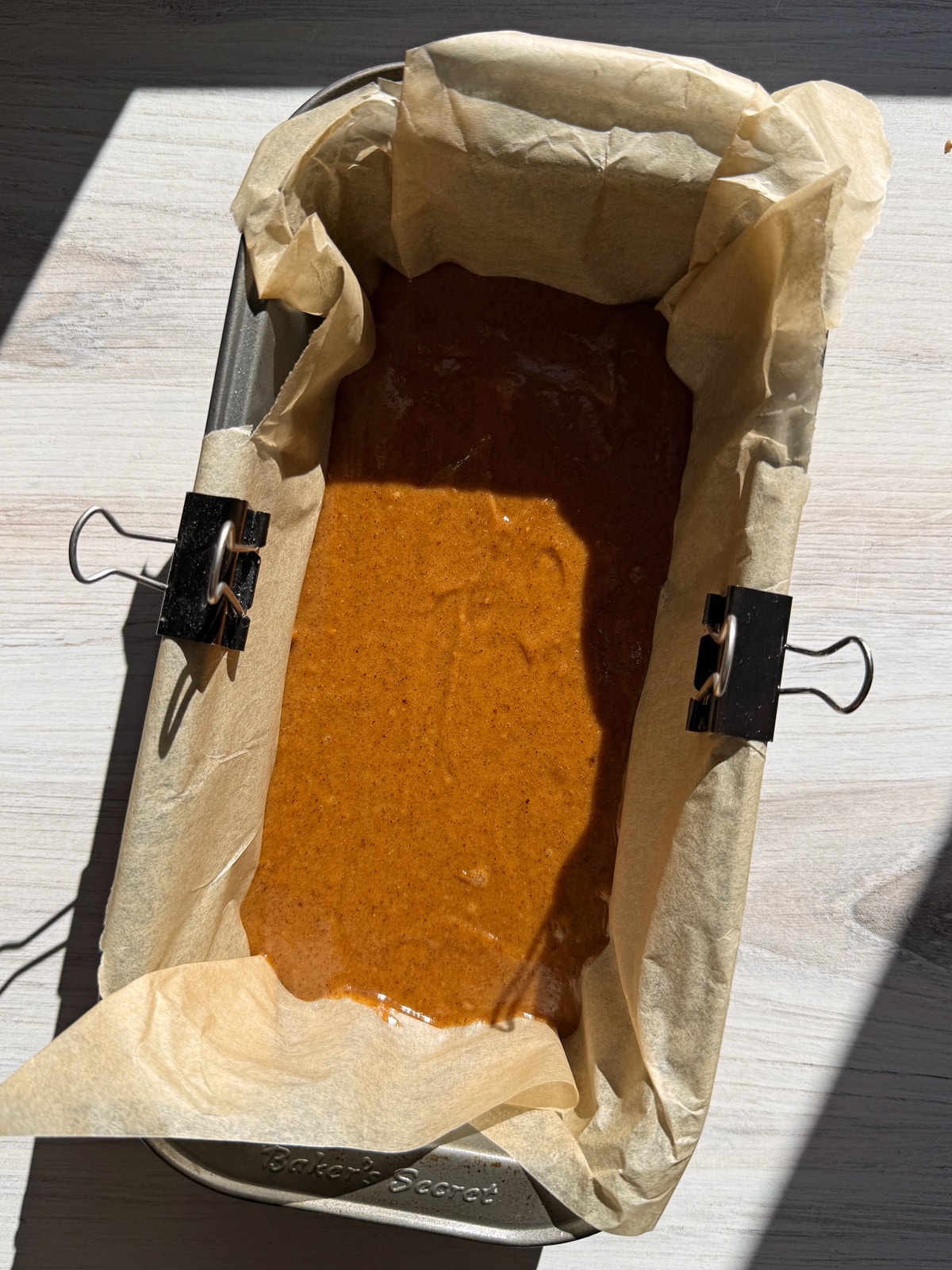 Caramel spread into a lined 8x4 inch loaf pan, ready to freeze.