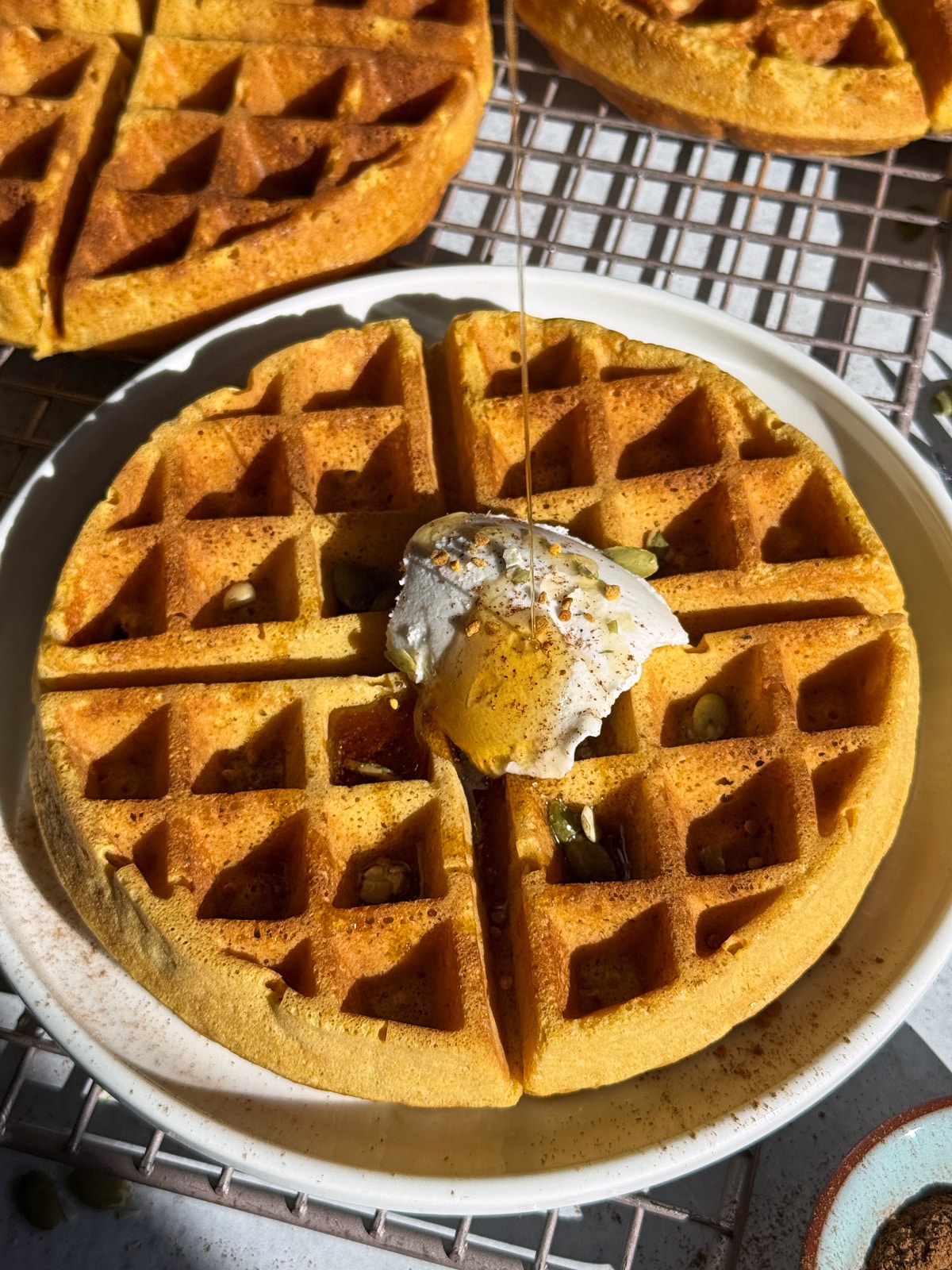 Drizzling maple syrup on the waffles.