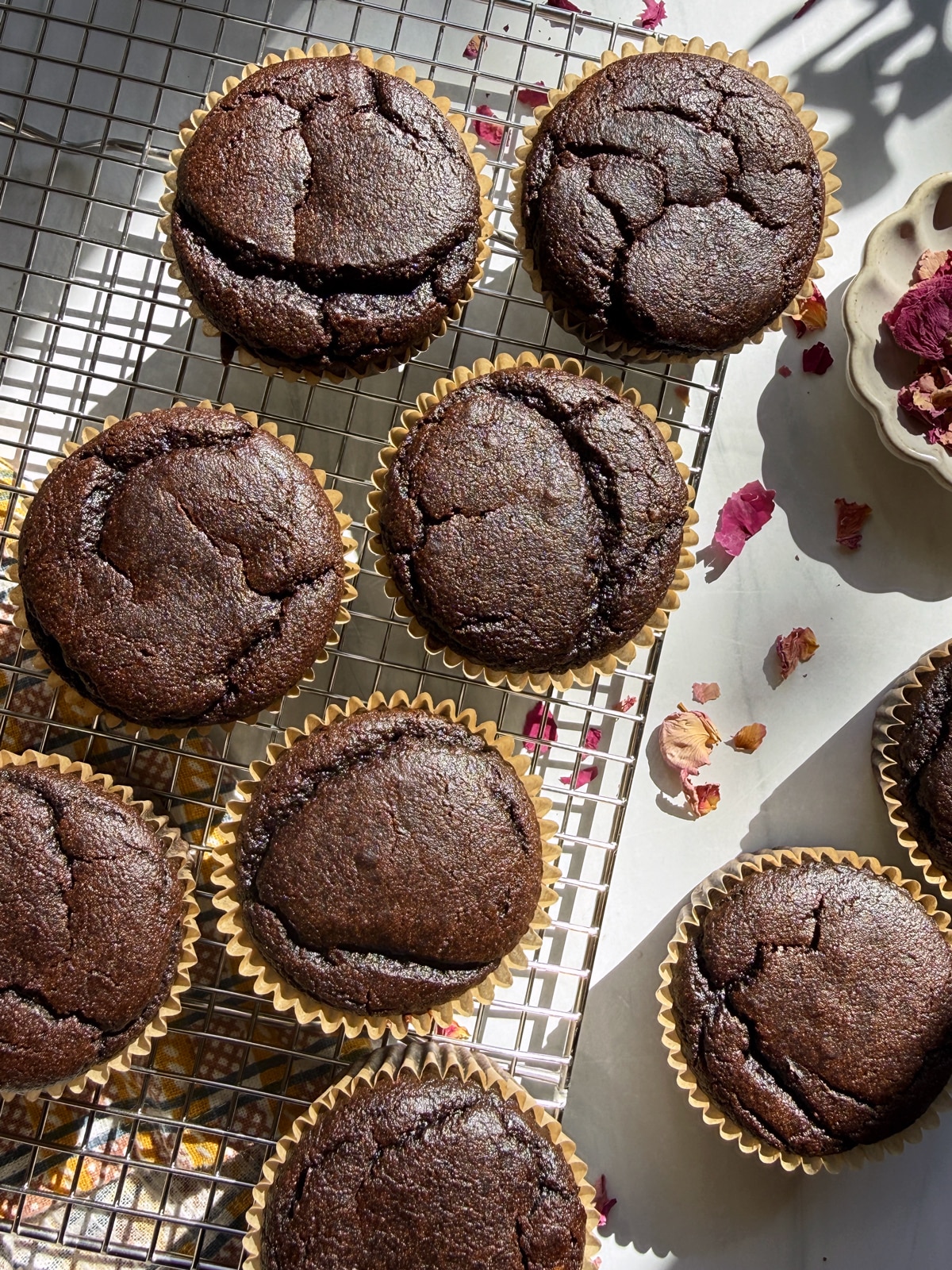 Baked cupcakes cooling on a wire rack.