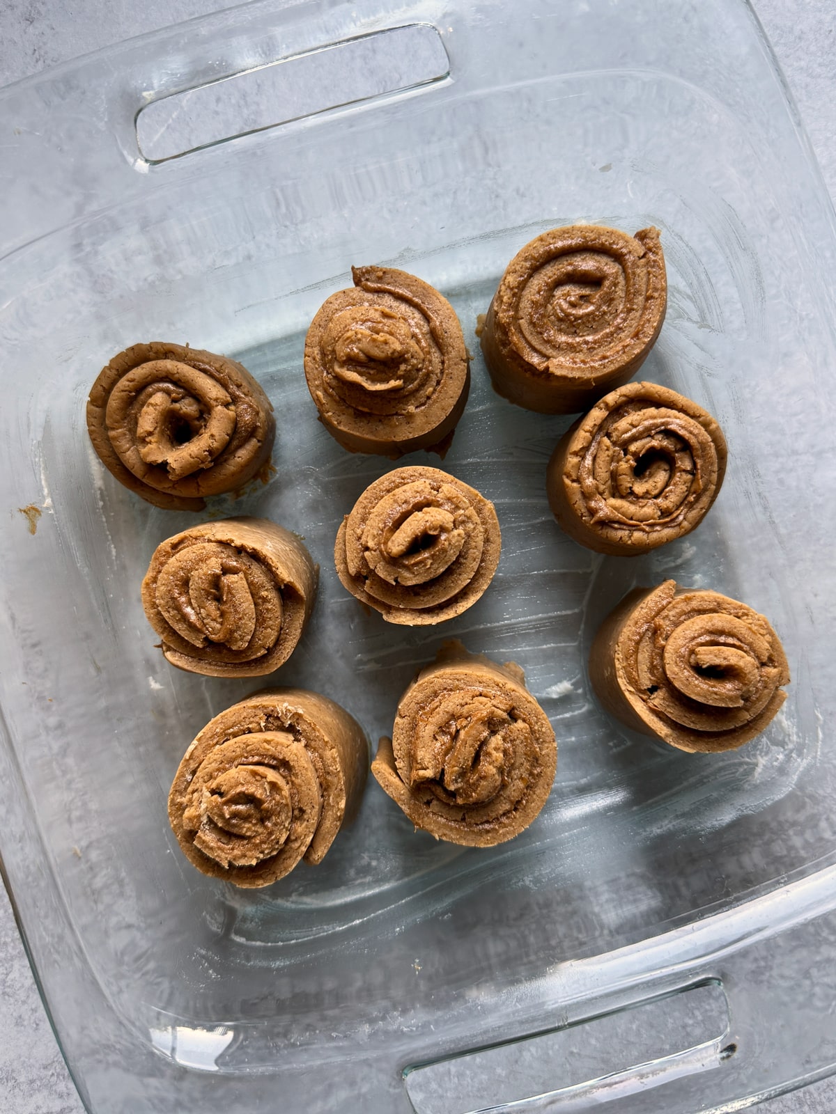 Cinnamon rolls in baking dish, ready to bake.