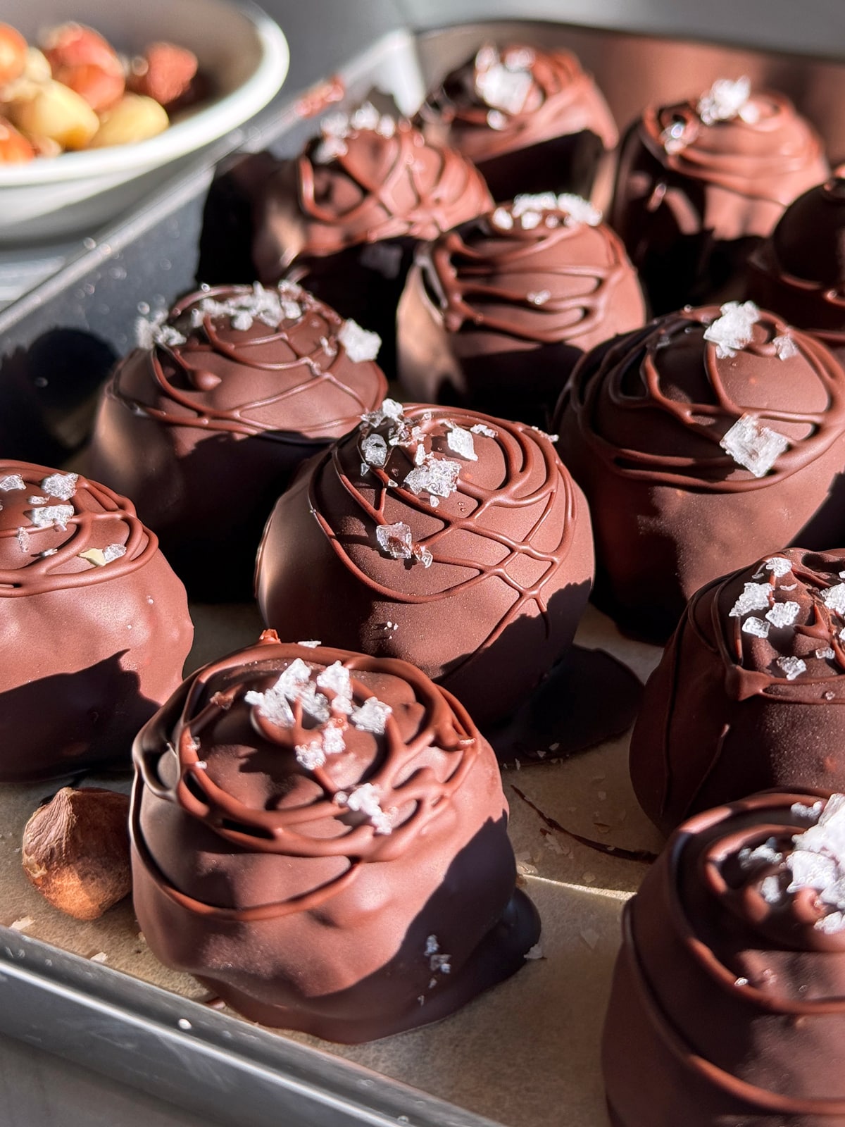 Side view of hazelnut truffles topped with flaked salt.
