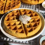 Paleo pumpkin waffles topped with coconut cream, bee pollen and pumpkin seeds.