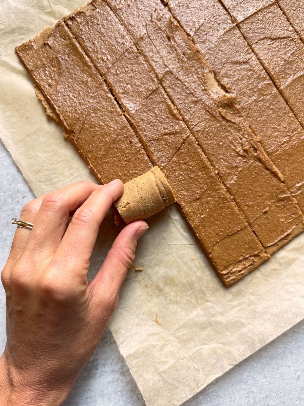 Cut dough that's being rolled into cinnamon rolls.