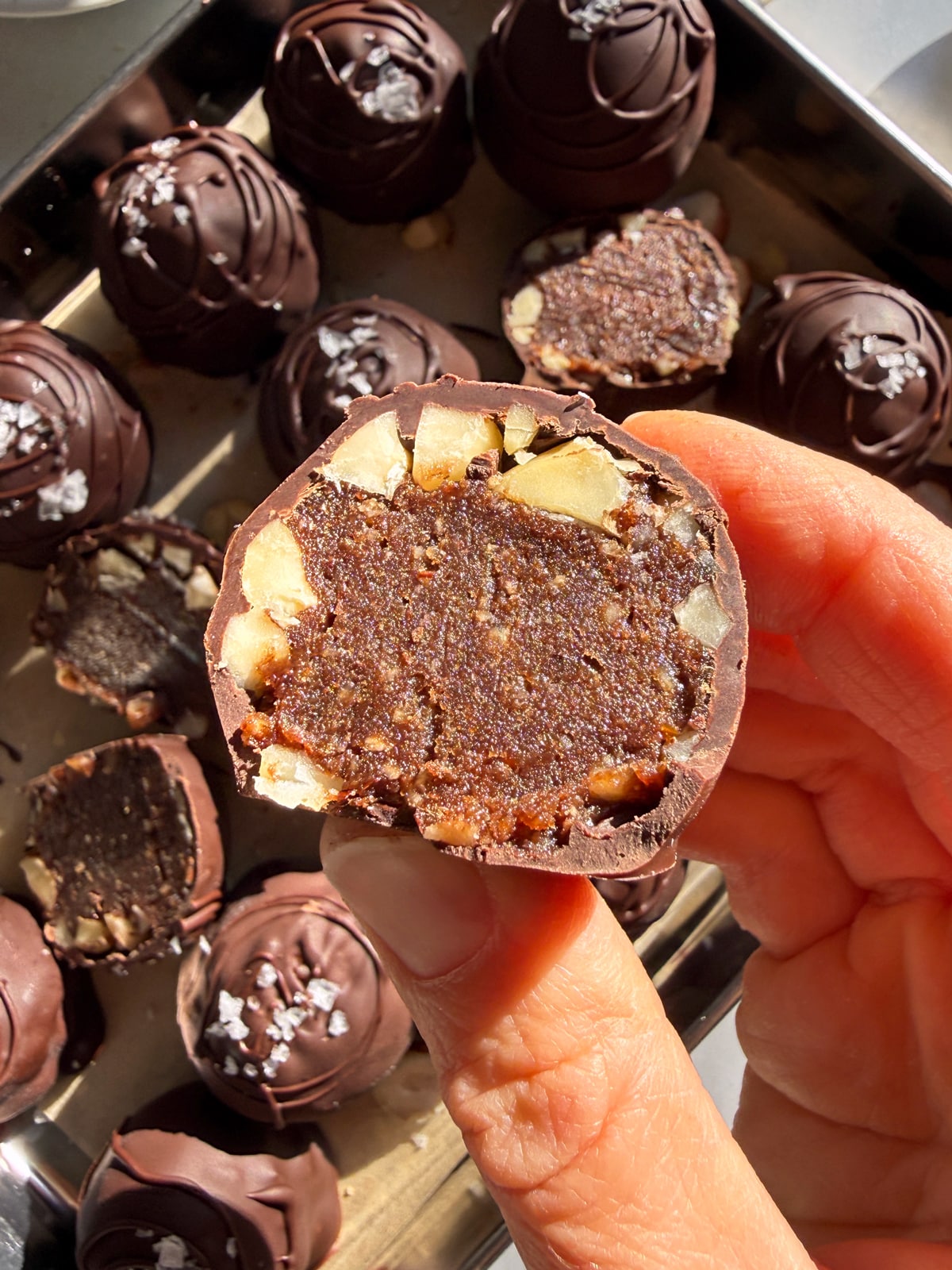 Holding a truffle that's been cut in half.